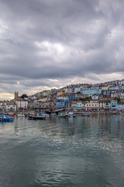Town wiht many colourful buildings next to a large harbour on a grey day