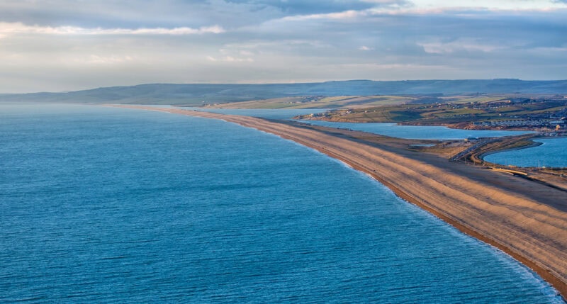 Aerial view of a long sandbank between the sea and a lagoon on the mainland 